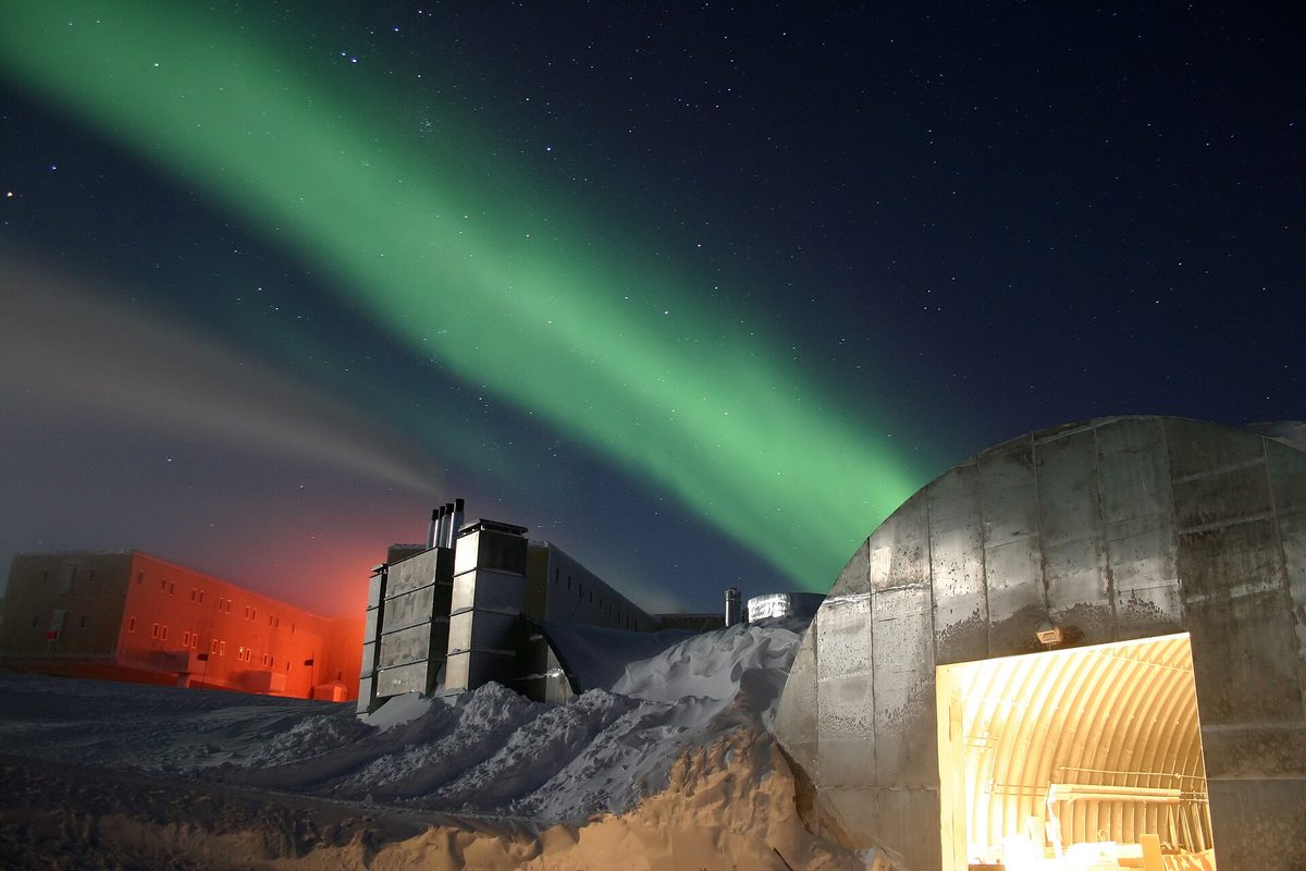 The aurora australis glowing over an Antarctic research station