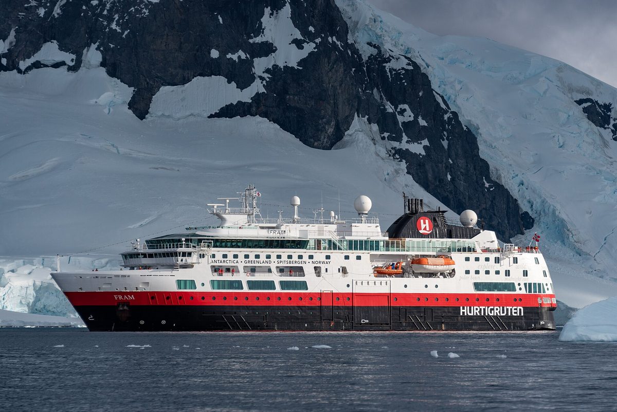 Expedition cruise ship in Antarctic waters surrounded by ice