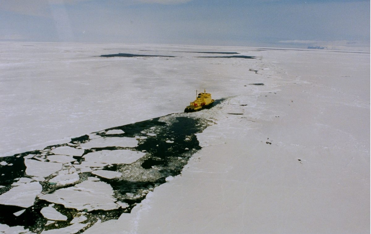 Aerial view of a polar icebreaker carving a channel through Antarctic pack ice