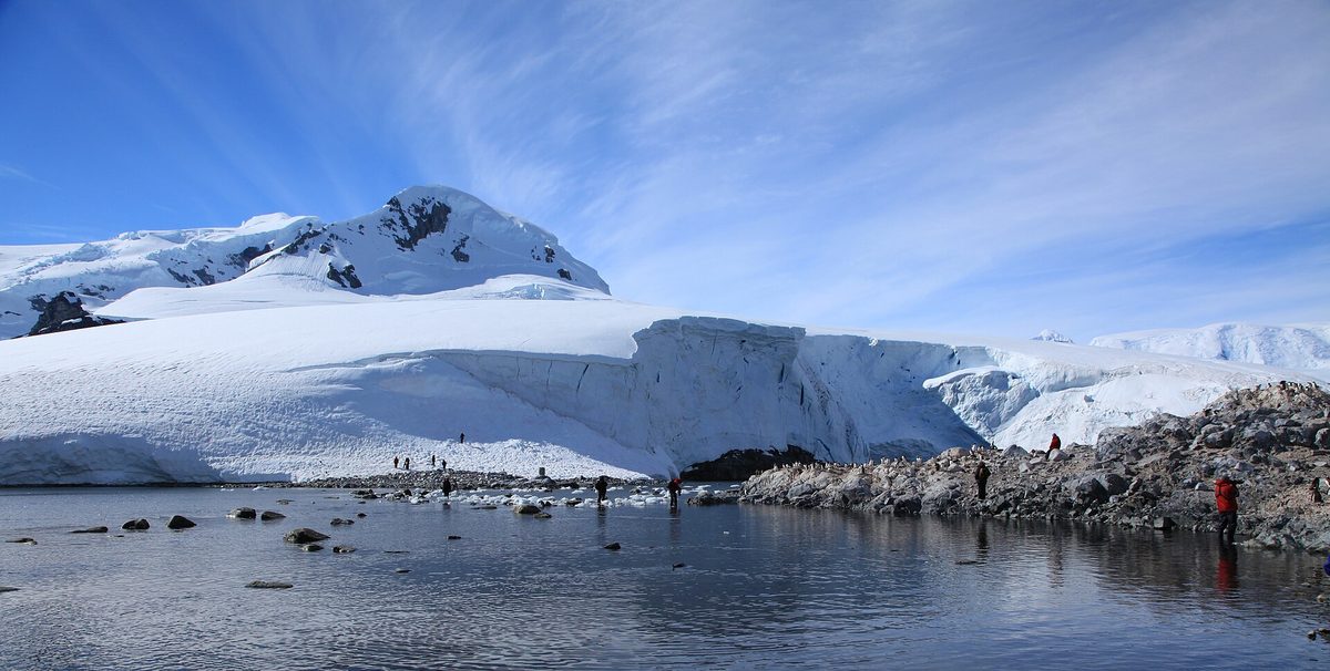 Expedition travellers ashore among penguins on the Antarctic Peninsula