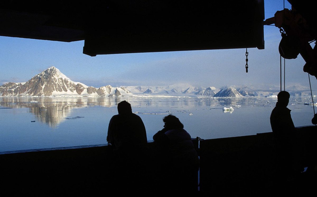 An expedition ship passing an iceberg in Antarctica
