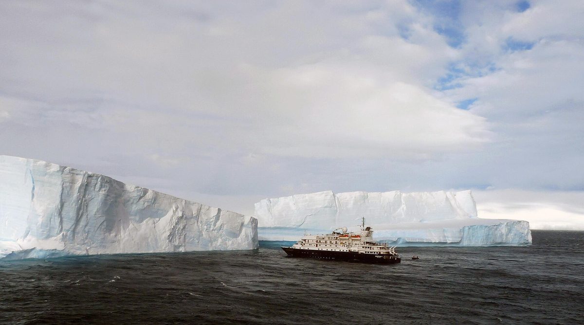 Travelers in a Zodiac cruising past ice on an Antarctica cruise